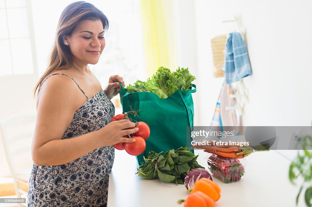 USA, New Jersey, Jersey City, Woman taking out vegetables of grocery bag