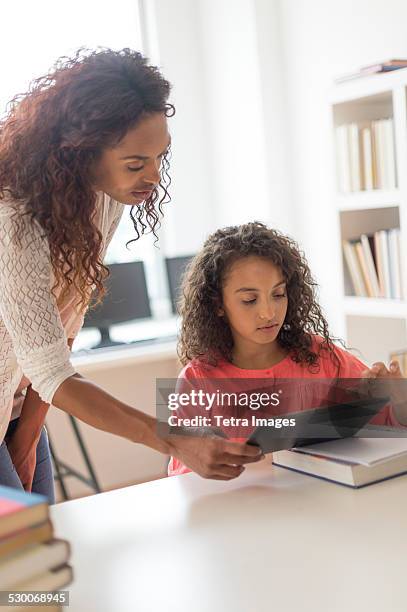 usa, new jersey, jersey city, girl (8-9) and teacher using digital tablet in classroom - tetra images teacher stock pictures, royalty-free photos & images