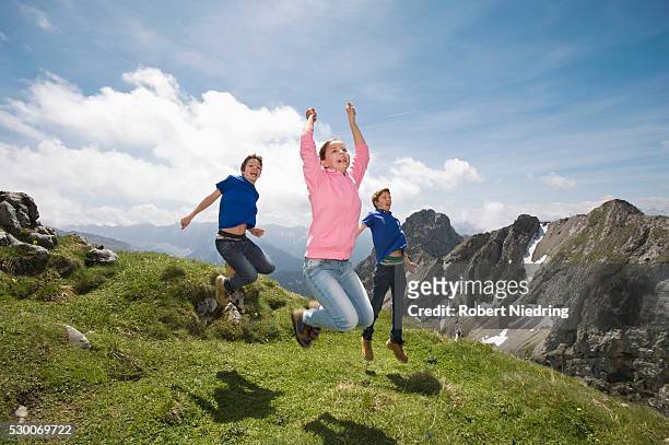 girl and teenage boys jumping in air alps - hiking across the karwendel mountain range stock pictures, royalty-free photos & images
