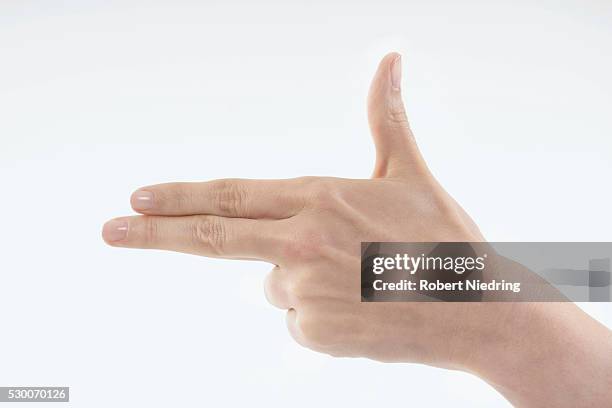 close-up of woman's hand making gun sign, bavaria, germany - finger studio close up stock-fotos und bilder