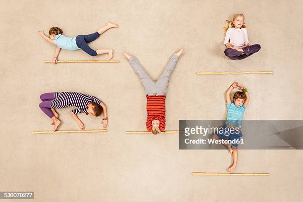 children doing gymnastics - child yoga elevated view stock pictures, royalty-free photos & images