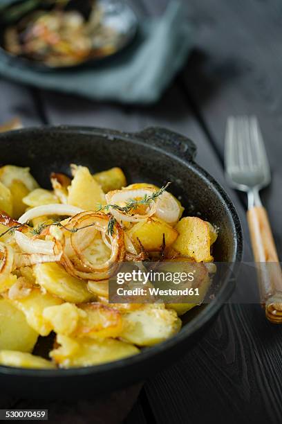 fried potatoes with onion rings and thyme - fried potato stock pictures, royalty-free photos & images