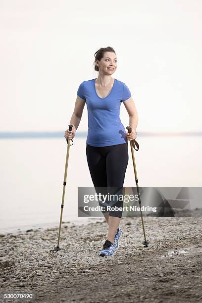 mature woman hiking at lakeshore, bavaria, germany - mobility walker stock-fotos und bilder