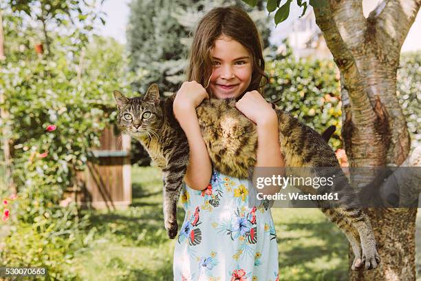 girl holding cat in garden - summer pets stock pictures, royalty-free photos & images