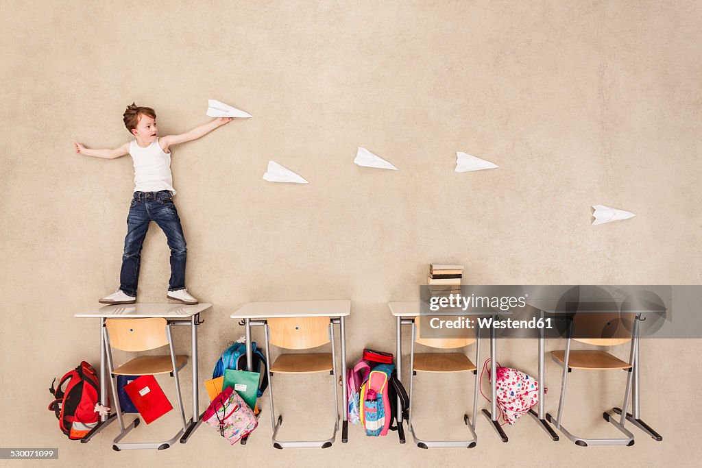 Boy throwing paper planes