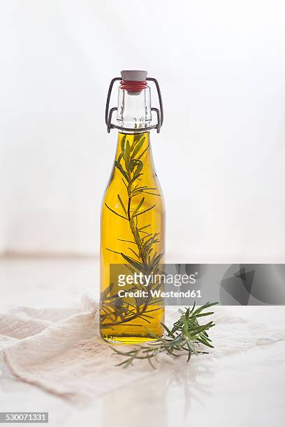 rosemary oil, rosemary twig in olive oil - oil bottle stock pictures, royalty-free photos & images