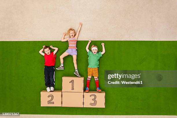 children standing on podium - winners podium imagens e fotografias de stock