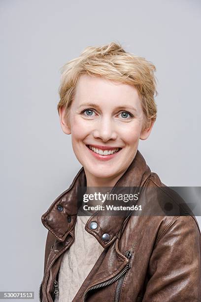 portrait of smiling woman with blond short hair - una mujer de mediana edad solamente fotografías e imágenes de stock