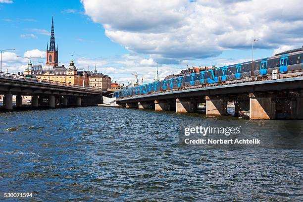 train on railway bridge in city, gamla stan, stockholm, sweden - stockholm metro stock pictures, royalty-free photos & images