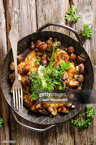 fresh potato rosti in a pan with mushrooms and salad - pastel de patata fotografías e imágenes de stock