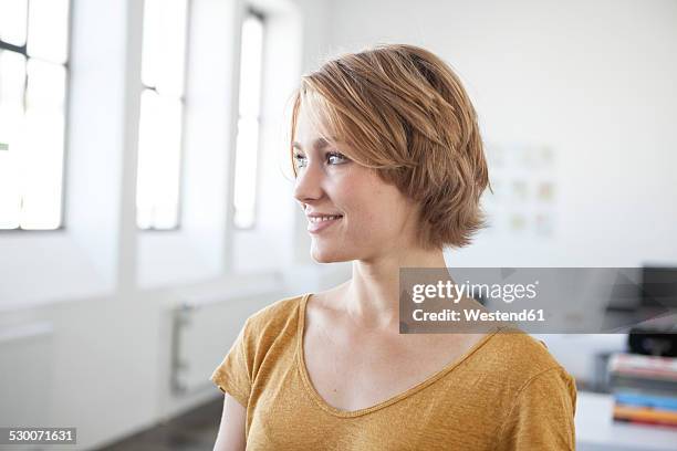 portrait of smiling young woman in a creative office - blonde short hair stock pictures, royalty-free photos & images