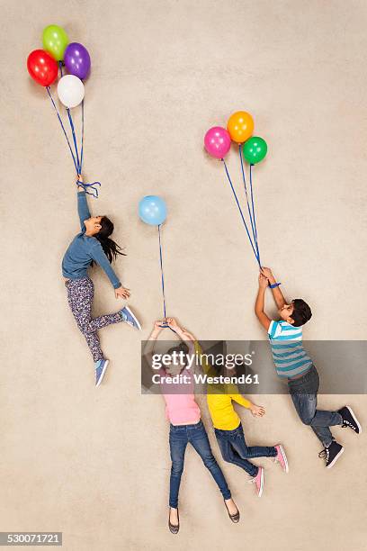 children flying away on balloons - balloon girl fotografías e imágenes de stock