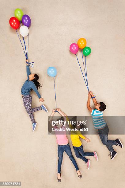 children flying away on balloons - child balloon studio photos et images de collection