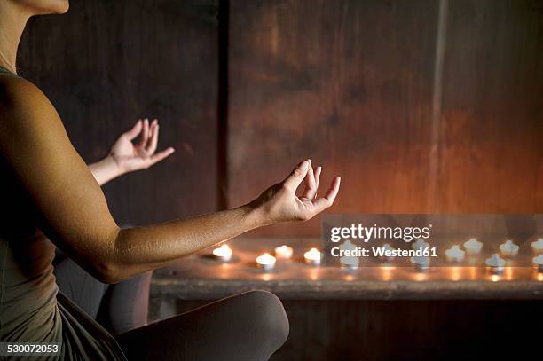 woman meditating in wooden house - candle light foto e immagini stock