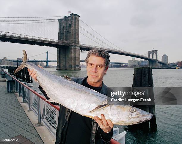 Chef Anthony Bourdain is photographed in June 2003 holding up a mackerel at the Fulton Fish Marketin New York City.