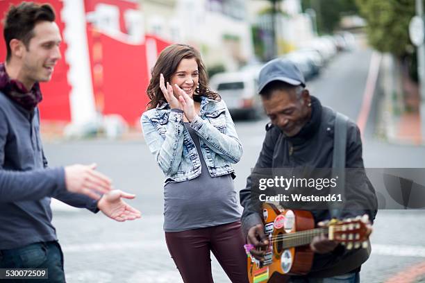 young couple listening to guitar player on the street - busker 個照片及圖片檔