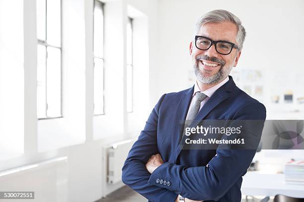 portrait of smiling businessman with crossed arms in an office - white jacket 個照片及圖片檔