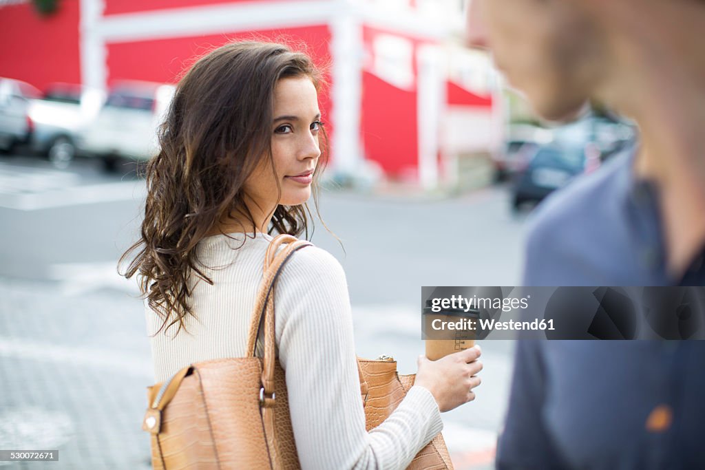 Portrait of woman with coffee to go