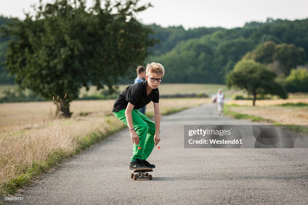 Boy skateboarding on a rural street