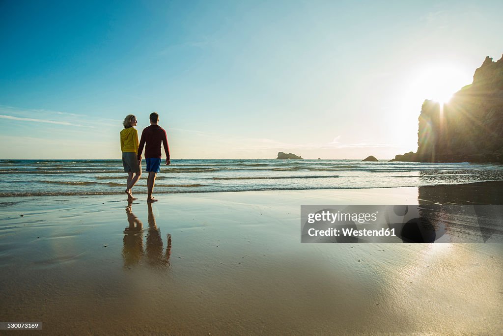 France, Brittany, Camaret-sur-Mer, teenage couple on the beach walking on the beach