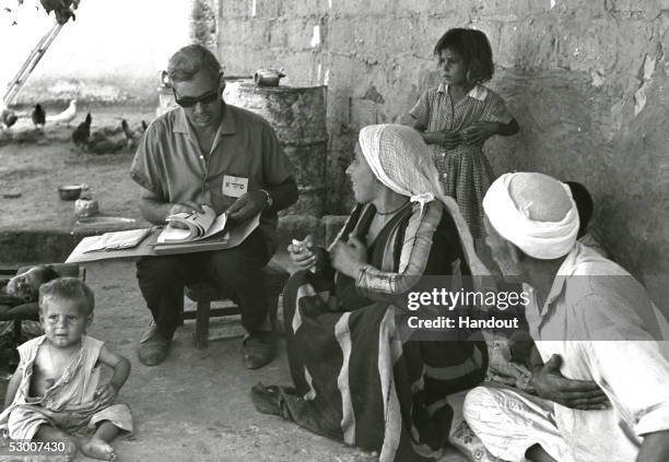 In this handout photo from the GPO, Israeli census taker Josef Levy interviews a Palestinian family in their courtyard just three months after the...