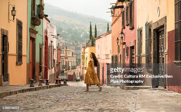 female tourist strolling on street, san miguel de allende, guanajuato, mexico - guanajuato photos et images de collection