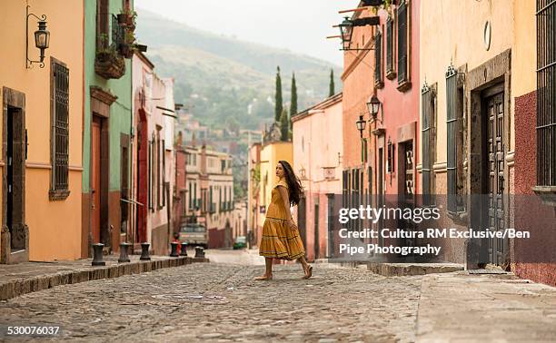 female tourist strolling on street, san miguel de allende, guanajuato, mexico - woman walking side view stock pictures, royalty-free photos & images