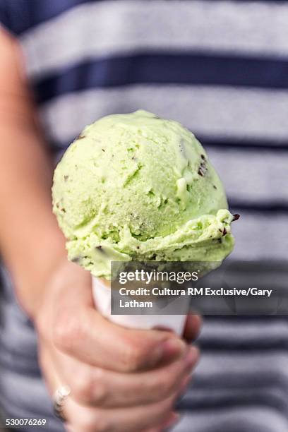 cropped close up of hand holding ice cream cone - mint ice cream stock pictures, royalty-free photos & images