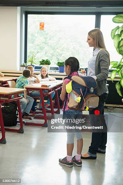 female teacher introducing a new classmate in classroom, munich, bavaria, germany - the new school stock pictures, royalty-free photos & images