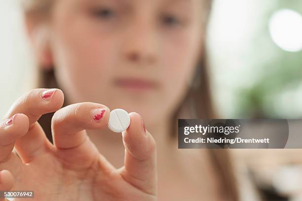 schoolgirl showing a pill in classroom, munich, bavaria, germany - adhd child imagens e fotografias de stock