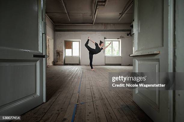 mid adult woman practicing natarajasana pose in yoga studio, munich, bavaria, germany - laminat stock-fotos und bilder