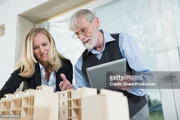 two architects looking at architectural model - architekturmodell stock-fotos und bilder