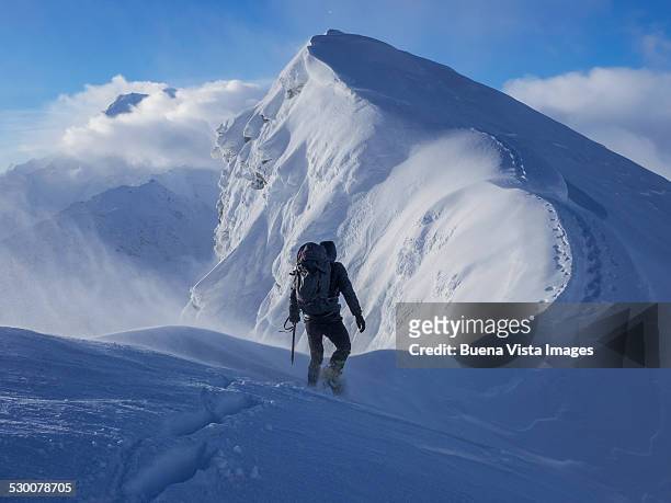 climber on a snowy edge - climbing snow mountain stock pictures, royalty-free photos & images