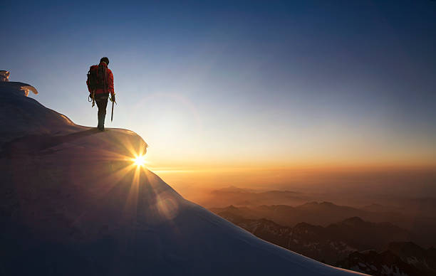 climber on a snowy range at sunset - 決意 ストックフォトと画像