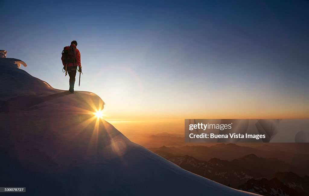 Climber on a snowy range at sunset