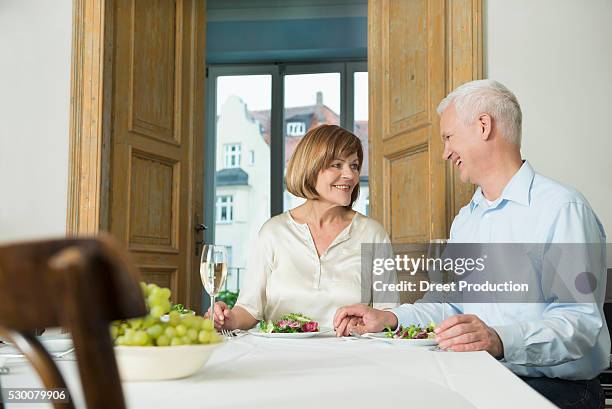 couple sitting at table and looking at each other, smiling - smiling woman on gray background 50 stock pictures, royalty-free photos & images