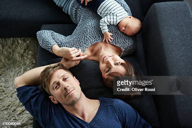 family with baby boy relaxing on couch - baby human age stock-fotos und bilder