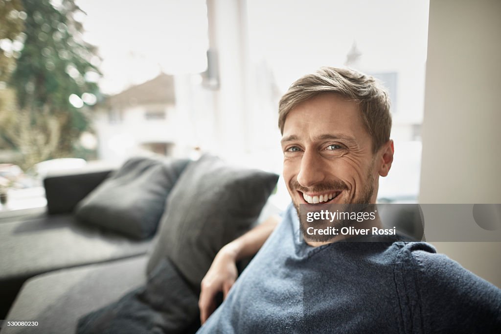 Portrait of smiling man in living room