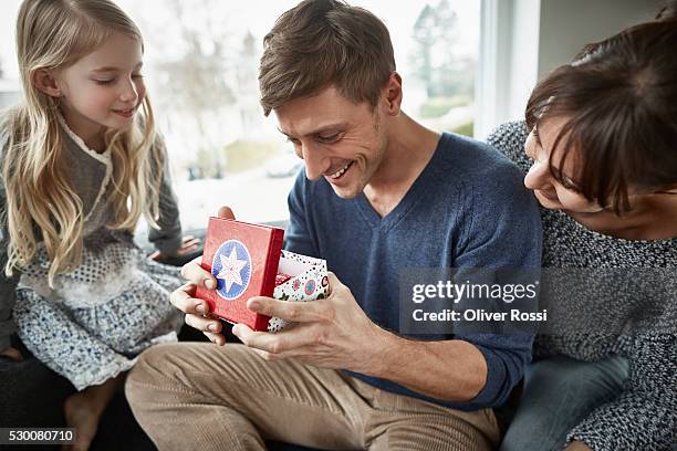 happy father receiving gift from his family - fathers day bildbanksfoton och bilder