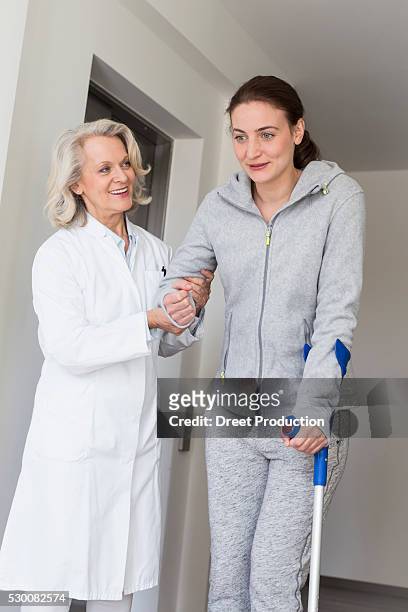 patient with crutches prcticing to walk - acupuncture elderly stock pictures, royalty-free photos & images