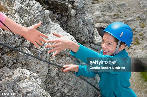 hand helping teenage boy climbing alps reaching - 爬山繩 個照片及圖片檔