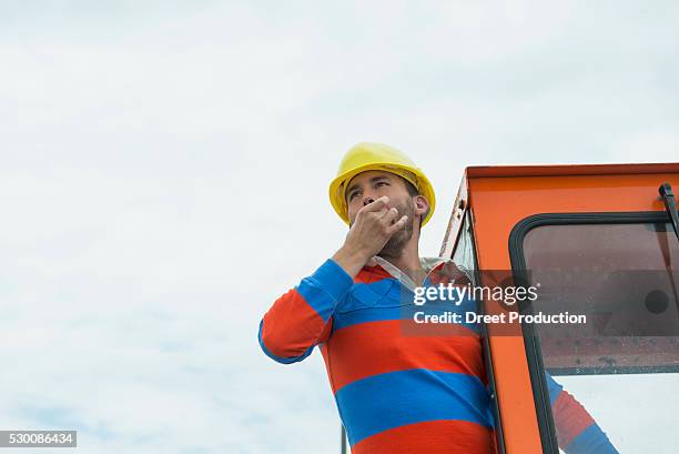 construction worker on site with excavator - fluit sportartikelen stockfoto's en -beelden