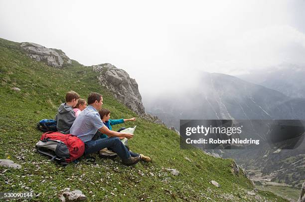 father and kids looking at hiking map mountains - hiking across the karwendel mountain range stock pictures, royalty-free photos & images