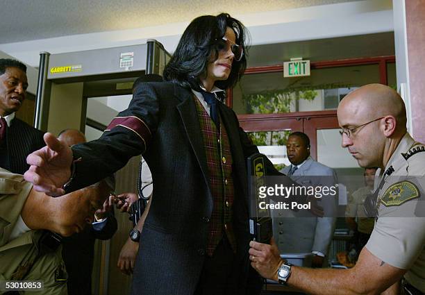 Michael Jackson goes through security as he arrives for closing arguments in his child molestation trial at Santa Barbara County Superior Court June...