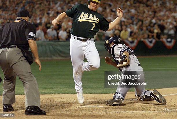 Jeremy Giambi of the Oakland A's is tagged out by Jorge Posada of the New York Yankees during game three of the American League Divisional Series at...