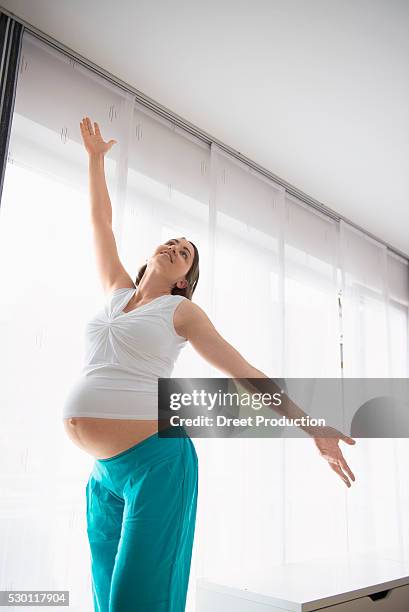 young pregnant woman happy dancing posing - belly dancer stockfoto's en -beelden