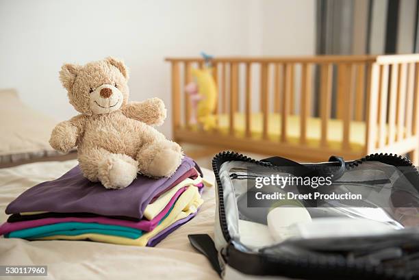 baby bedroom cot teddy bear clothes suitcase - baby clothes stock pictures, royalty-free photos & images