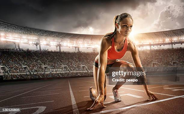 girl athlete getting ready to run - starting block stockfoto's en -beelden