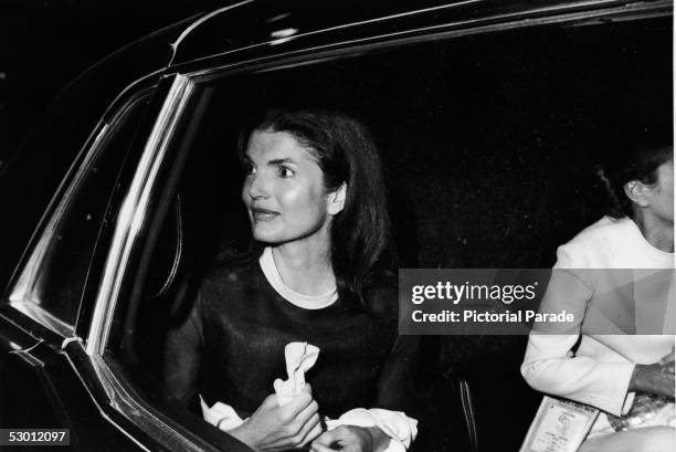 American former first lady Jacqueline Kennedy Onassis , the wife of Greek shipping magnate Aristotle Onassis, looks out from her car window as she...