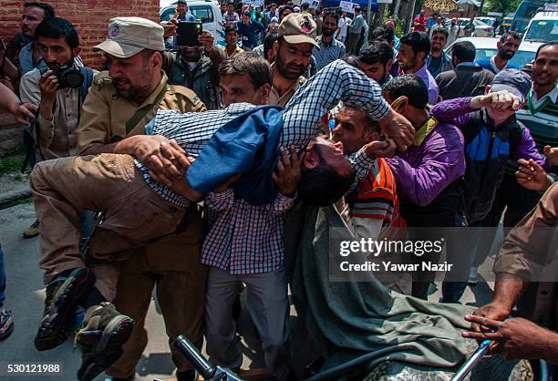 Indian Police detain a disabled member of All Jammu and Kashmir Handicapped Association shout anti government slogans during an anti government...